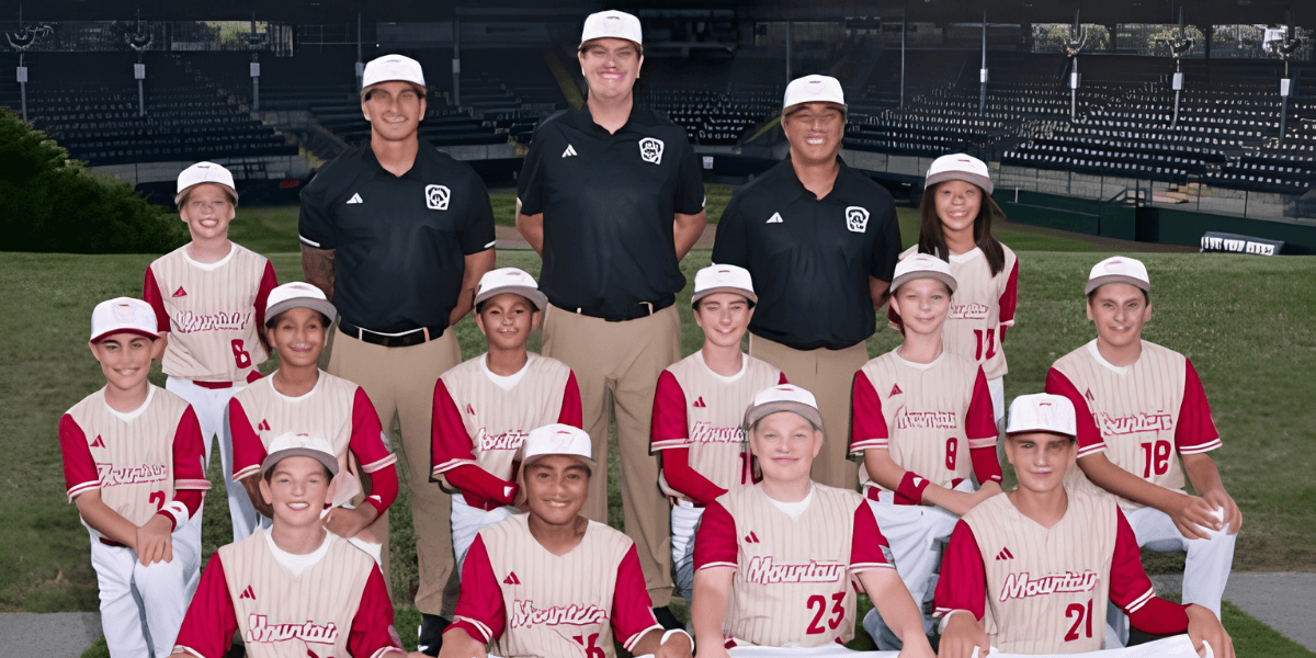 Youth baseball team and coaches posed on the field wearing matching uniforms and caps