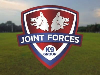Joint Forces K9 Group logo over grassy field promoting professional dog training and boarding services in Northwest Arkansas.