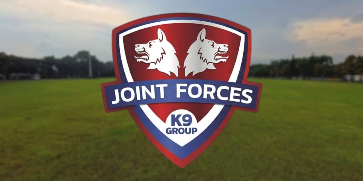 Joint Forces K9 Group logo over grassy field promoting professional dog training and boarding services in Northwest Arkansas.