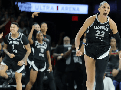 Celebrating basketball players in black jerseys during a tense moment in the game