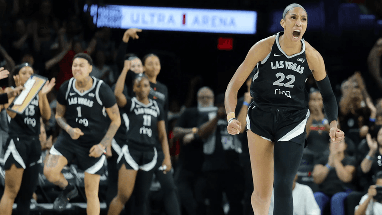 Celebrating basketball players in black jerseys during a tense moment in the game