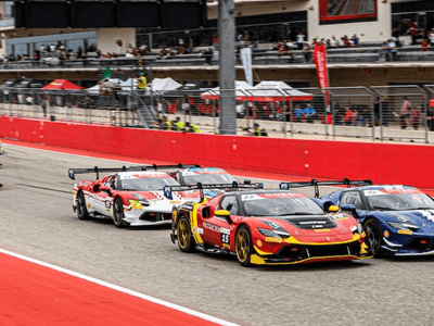 Race cars speeding on a track during a motorsport event with spectators in background