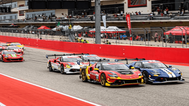 Race cars speeding on a track during a motorsport event with spectators in background