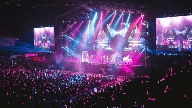 A vibrant concert scene with bright lights, a large audience, and performers on stage