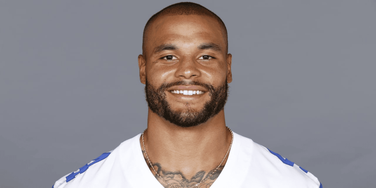 Smiling athlete wearing a football jersey, with a short beard and a gold chain