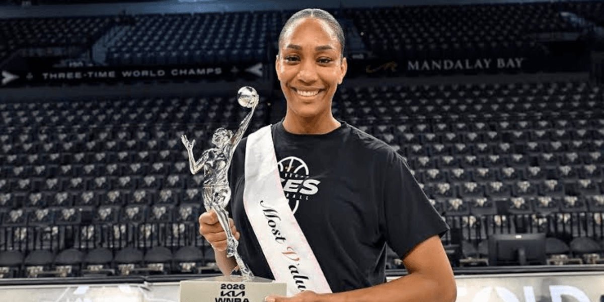 A female basketball player smiling proudly with a trophy and sash in her uniform