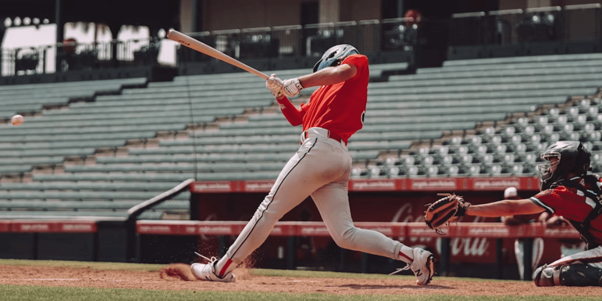 Baseball player swings at a pitch during an MLB game as the catcher reaches for the ball behind home plate.